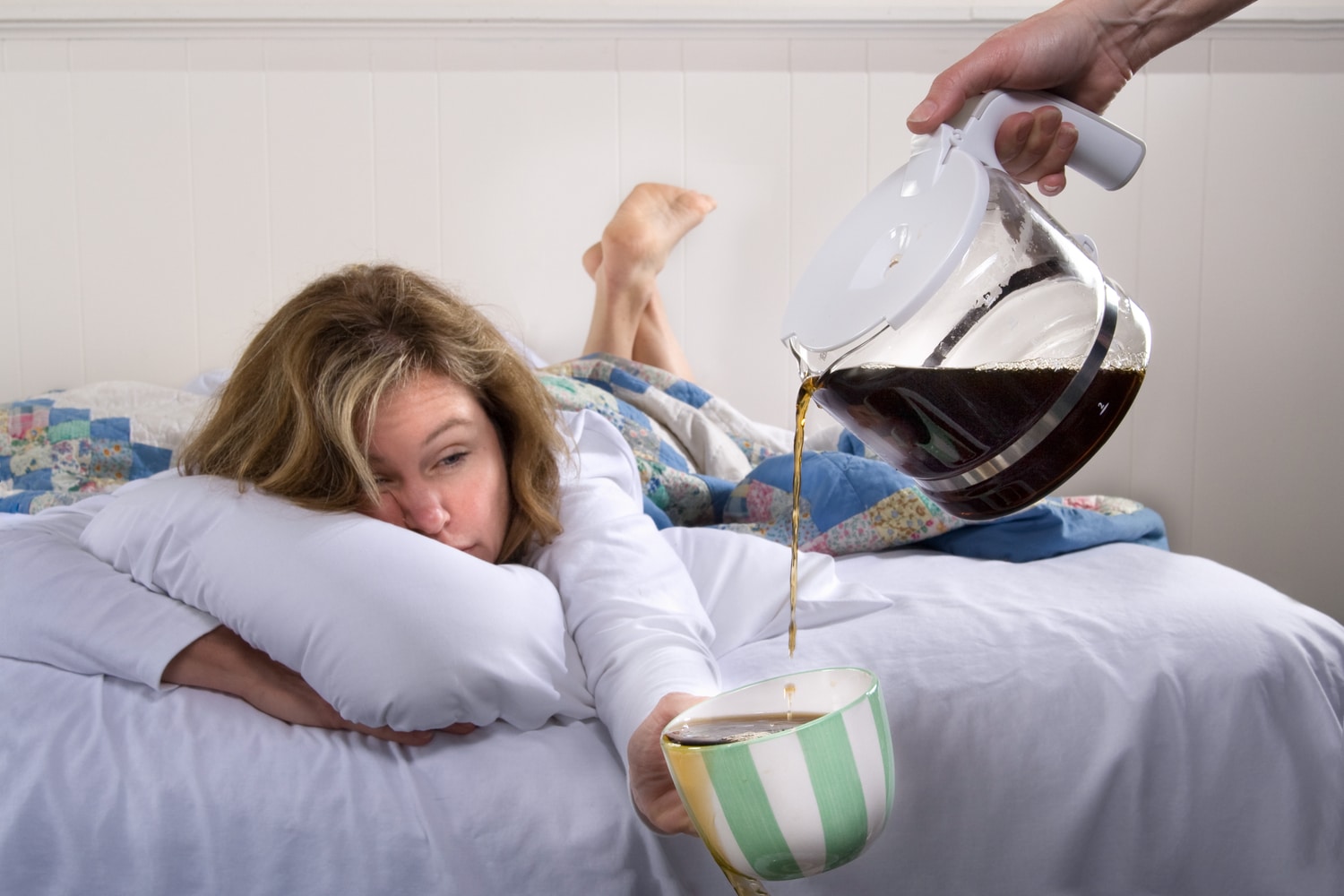 Hungover lady has a coffee in bed