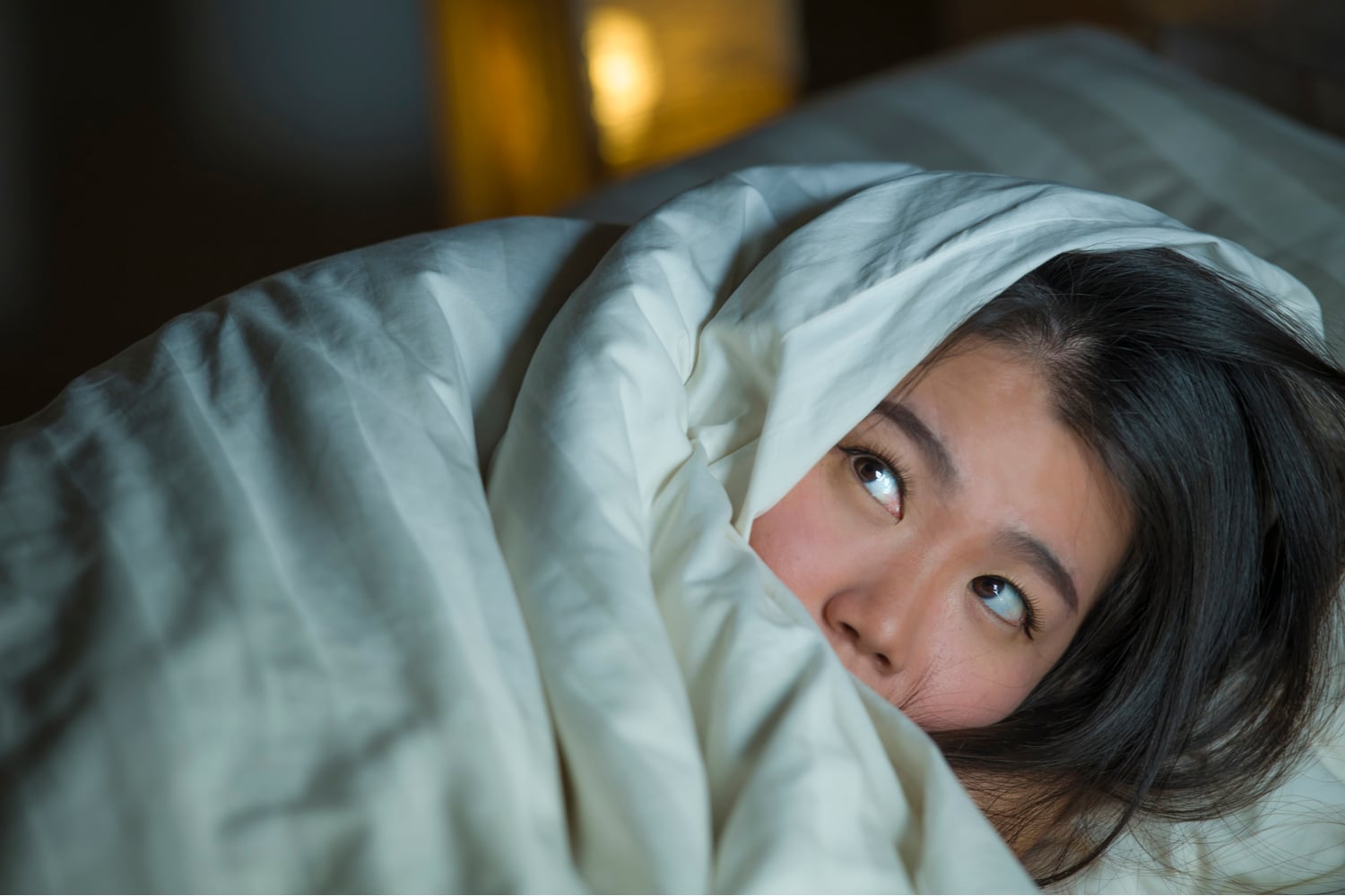 Anxious girl wraps herself in blanket